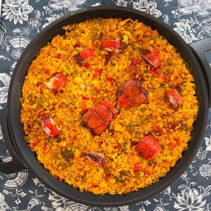 Kamado The Bastard abierto con un arroz con bogavante cocinándose sobre brasas de carbón.